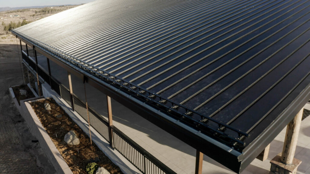 Edificio de oficinas con techo metálico de junta alzada y sistema de retención de nieve instalado en el alero.