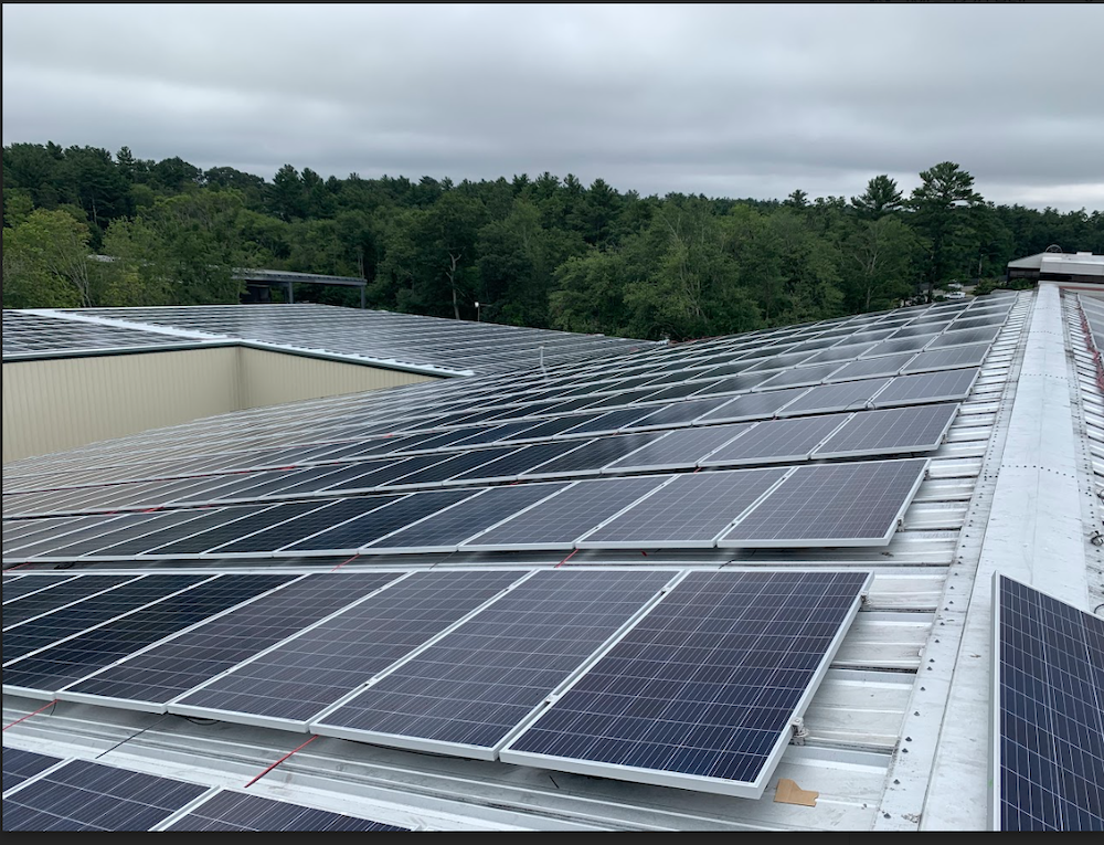 Solar panels installed on a metal roof, arranged in rows across the surface.
